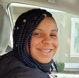 Girl in red shirt smiles at the camera