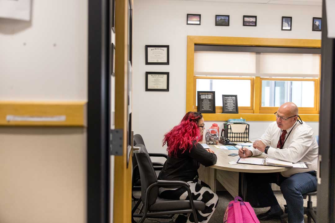 student and counselor facing over desks